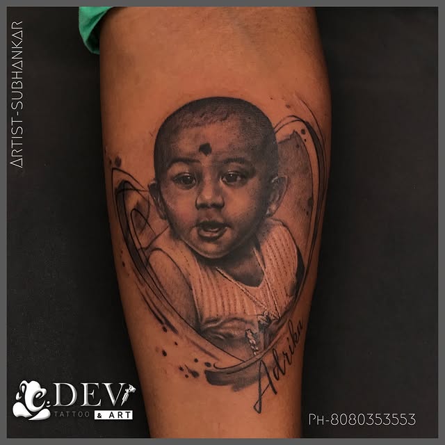 Baby portrait black and grey realism forearm tattoo by Subhankar, Dev Tattoo & Art Kolkata
